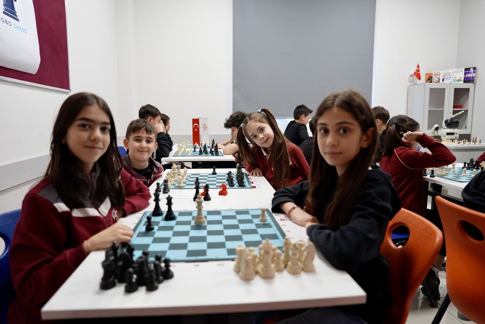 Grup dersinde çocuklar satranç tahtasının başında